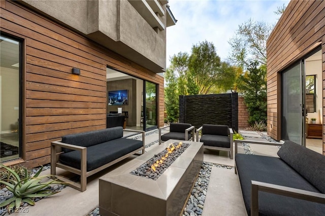 view of patio with an outdoor living space with a fire pit