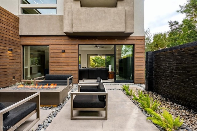view of patio with a jacuzzi and an outdoor fire pit