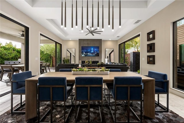 interior space featuring visible vents, ceiling fan, and a tray ceiling