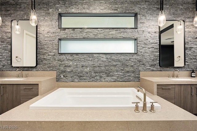 full bath with a garden tub, two vanities, a sink, and a wealth of natural light