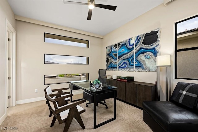home office with plenty of natural light, baseboards, ceiling fan, and light colored carpet