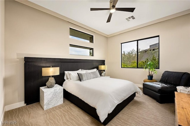 bedroom featuring visible vents, a ceiling fan, baseboards, and multiple windows