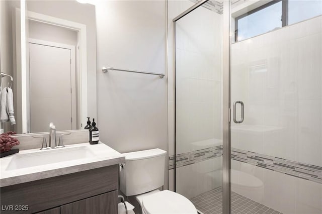 bathroom with toilet, vanity, and a stall shower