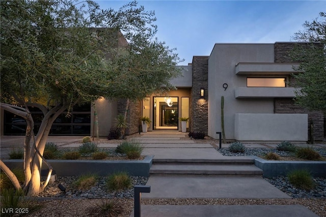 doorway to property with stone siding and stucco siding