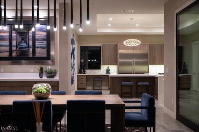 dining room featuring a tray ceiling, visible vents, recessed lighting, and an inviting chandelier