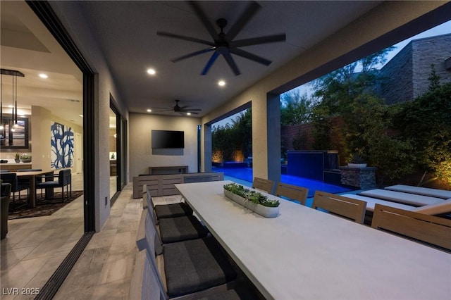 view of patio with an outdoor kitchen, a ceiling fan, fence, an outdoor pool, and outdoor dining space