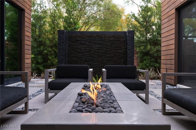 view of patio with an outdoor living space with a fire pit