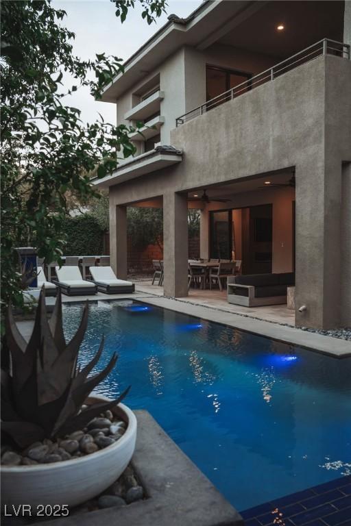 pool with a patio area, outdoor dining area, and ceiling fan