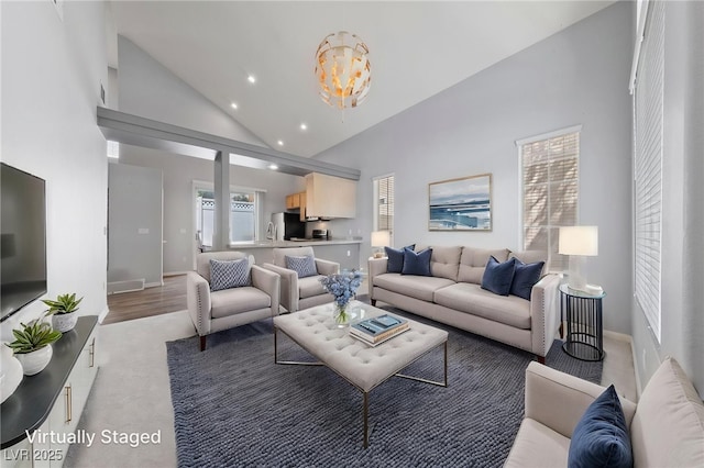 7589 Grassy Bank St, Las Vegas, NV 89139 - living area featuring a chandelier, high vaulted ceiling, recessed lighting, baseboards, and light carpet