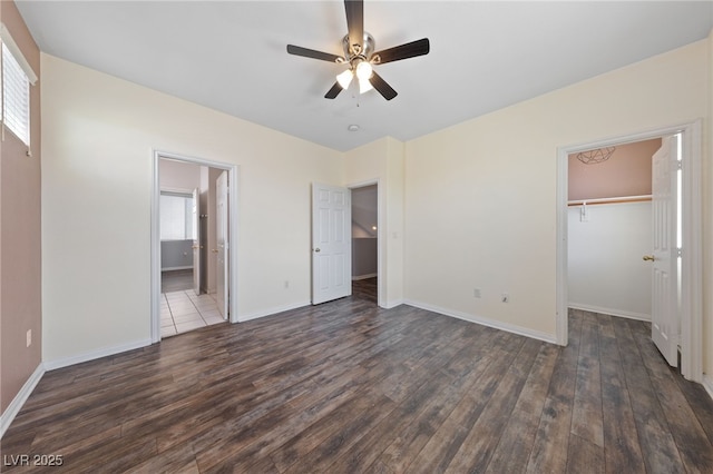 7589 Grassy Bank St, Las Vegas, NV 89139 - unfurnished bedroom featuring dark wood finished floors, a spacious closet, baseboards, a closet, and ceiling fan