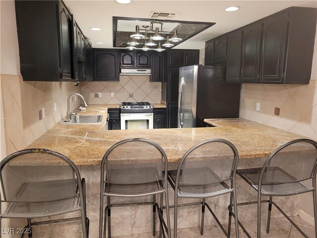 3621 Laguna Verde Way, Las Vegas, NV 89121 - kitchen with a sink, appliances with stainless steel finishes, light countertops, under cabinet range hood, and visible vents