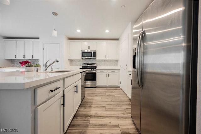 376 Yellow Finch Ln, Henderson, NV 89012 - kitchen featuring appliances with stainless steel finishes, a sink, white cabinets, light wood finished floors, and recessed lighting
