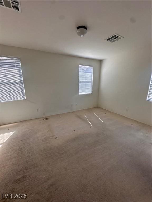 unfurnished room with light carpet and visible vents