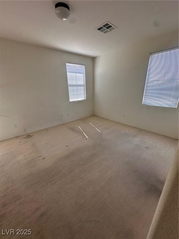 unfurnished room featuring visible vents and carpet flooring