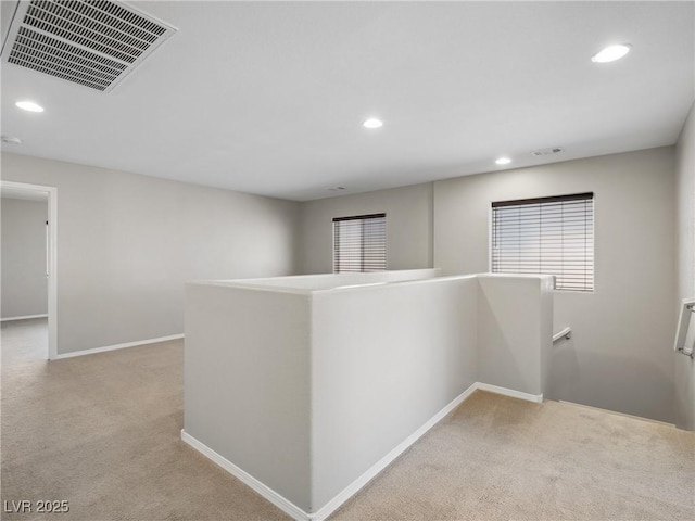 hall with an upstairs landing, carpet floors, recessed lighting, and baseboards