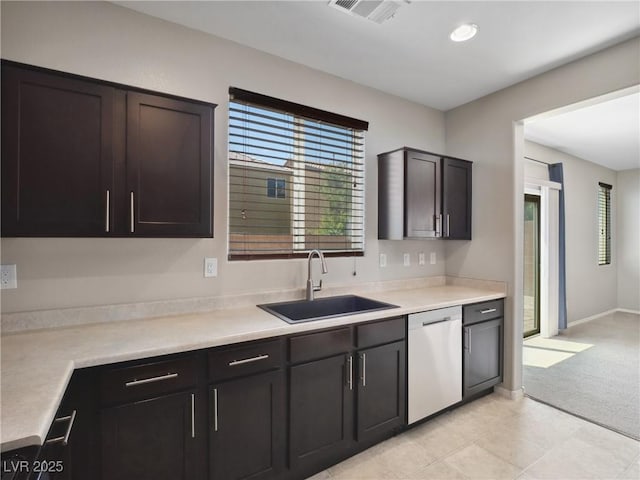 kitchen with a sink, stainless steel dishwasher, light countertops, light carpet, and recessed lighting
