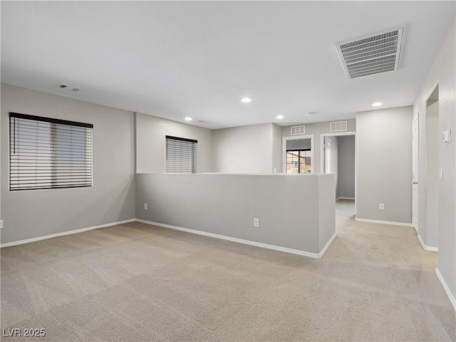 empty room with light carpet, baseboards, and recessed lighting