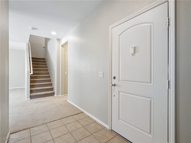 foyer entrance with light colored carpet, stairway, light tile patterned floors, baseboards, and recessed lighting