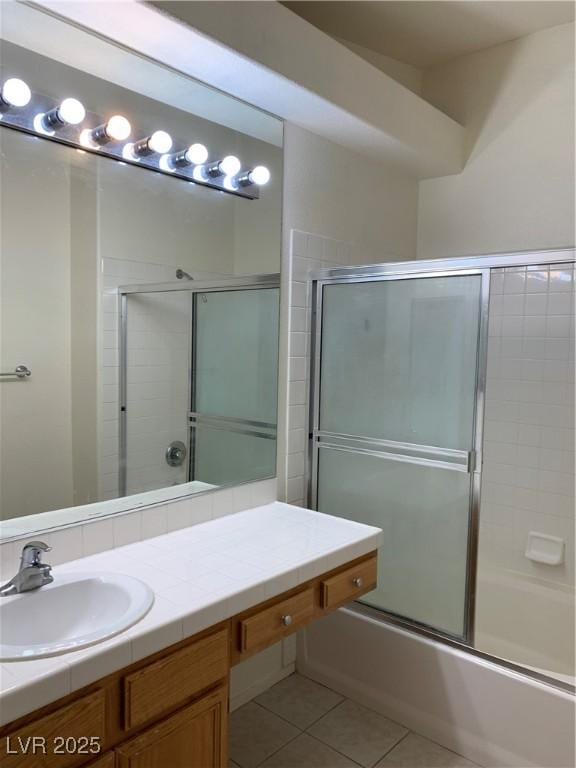 bathroom featuring vanity, tile patterned flooring, and bath / shower combo with glass door