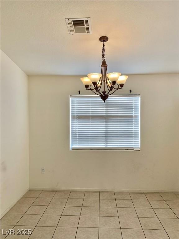 spare room with visible vents, a chandelier, and light tile patterned floors