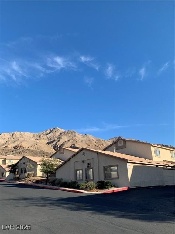 view of front facade with stucco siding and a mountain view