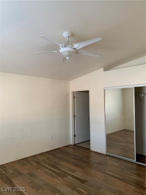 unfurnished bedroom featuring a ceiling fan, vaulted ceiling, two closets, and dark wood-style flooring