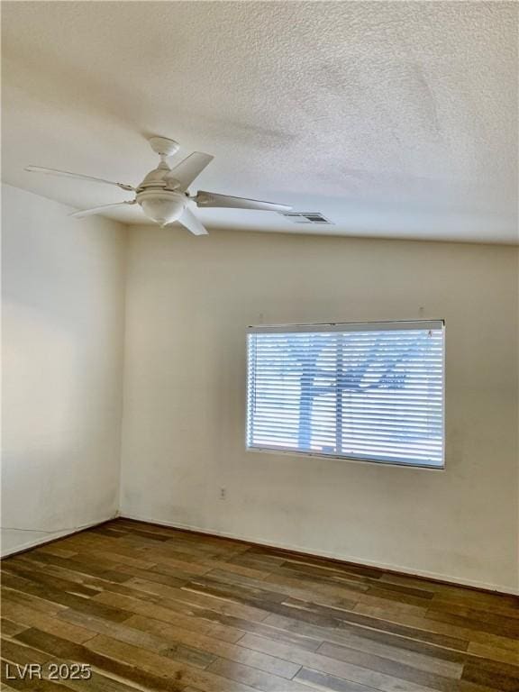 unfurnished room with wood-type flooring, visible vents, a textured ceiling, and ceiling fan