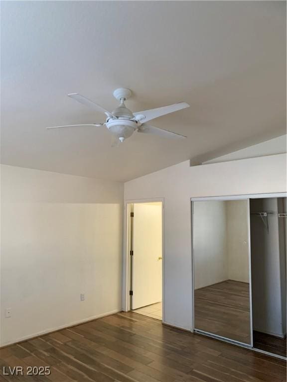 unfurnished bedroom with dark wood finished floors, lofted ceiling, ceiling fan, and a closet
