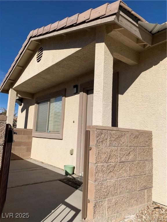 exterior space featuring a patio area, stucco siding, and fence