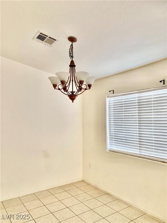 unfurnished room with visible vents, a notable chandelier, and light tile patterned floors