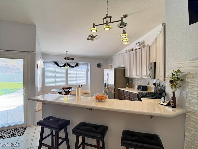 2022 Big Bend Way, Henderson, NV 89074 - kitchen featuring stainless steel appliances, a peninsula, decorative backsplash, lofted ceiling, and a kitchen breakfast bar