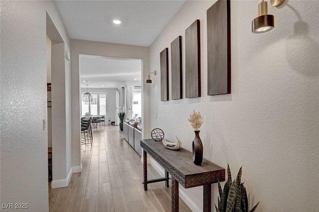 6544 Sandero Springs St, Las Vegas, NV 89166 - hallway with baseboards, a textured wall, light wood finished floors, and recessed lighting
