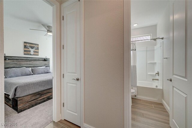 6544 Sandero Springs St, Las Vegas, NV 89166 - full bath with bathing tub / shower combination, wood finished floors, a ceiling fan, toilet, and baseboards