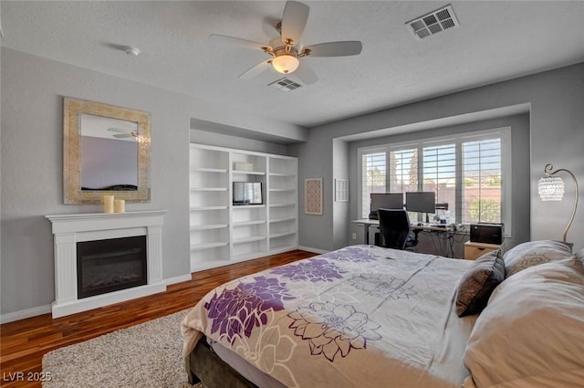 bedroom with baseboards, wood finished floors, and visible vents