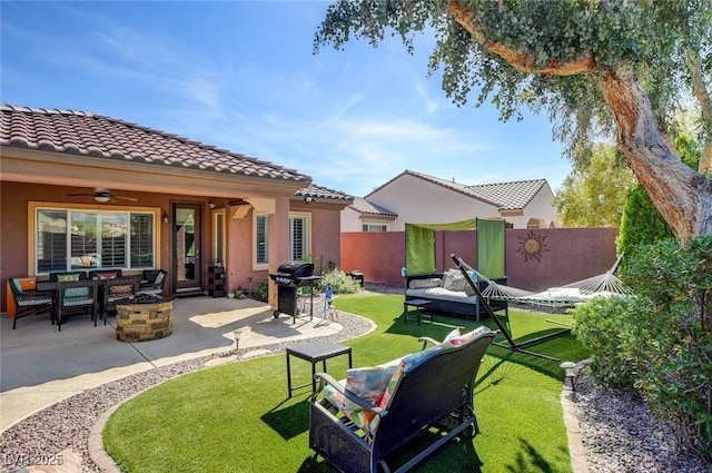 view of yard featuring fence, an outdoor living space with a fire pit, a patio, and ceiling fan