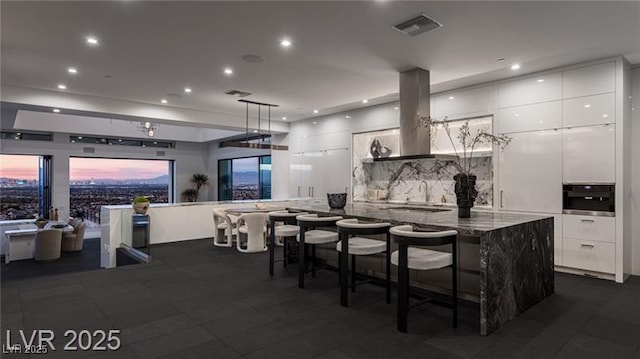 kitchen featuring modern cabinets, white cabinets, visible vents, and island exhaust hood