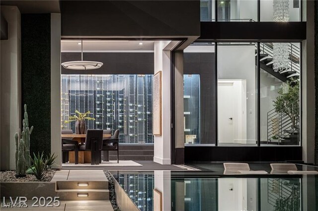 bedroom featuring floor to ceiling windows, light wood-type flooring, access to outside, a premium fireplace, and a notable chandelier