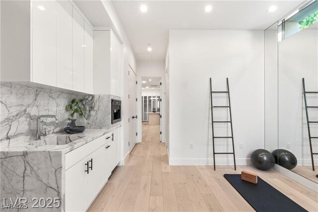 interior space with a sink, light wood finished floors, and recessed lighting