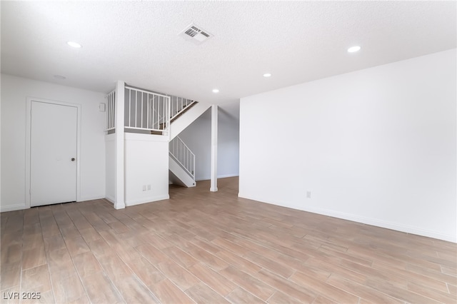 unfurnished living room with stairs, light wood finished floors, baseboards, visible vents, and recessed lighting