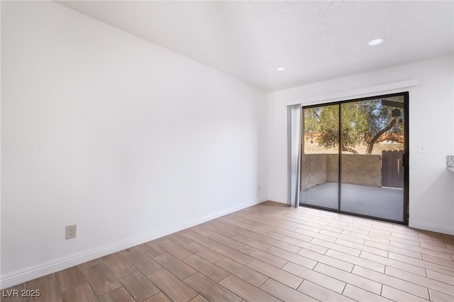 empty room featuring recessed lighting, wood finished floors, and baseboards