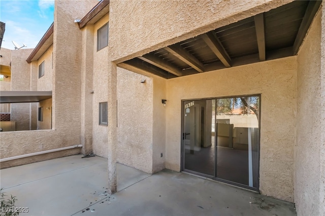 exterior space featuring a patio area and stucco siding