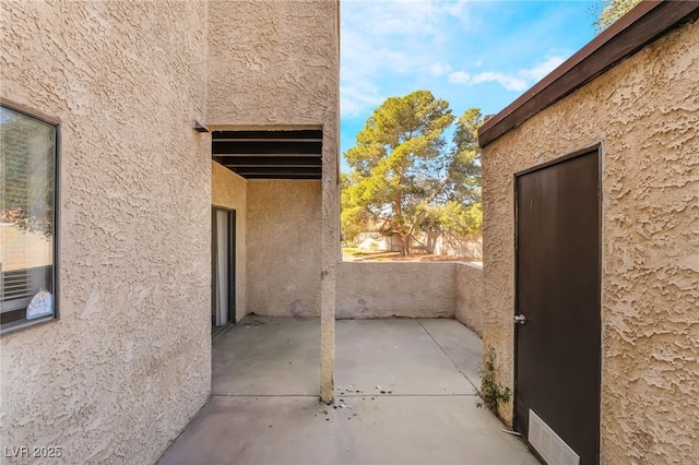 view of side of property featuring a patio and stucco siding