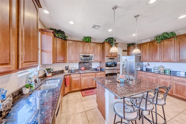 2733 Auchmull St, Henderson, NV 89044 - kitchen featuring stainless steel appliances, a breakfast bar area, a kitchen island, dark stone counters, and recessed lighting
