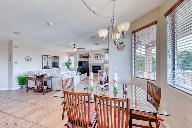 2733 Auchmull St, Henderson, NV 89044 - dining space featuring ceiling fan, light tile patterned floors, a glass covered fireplace, and a chandelier