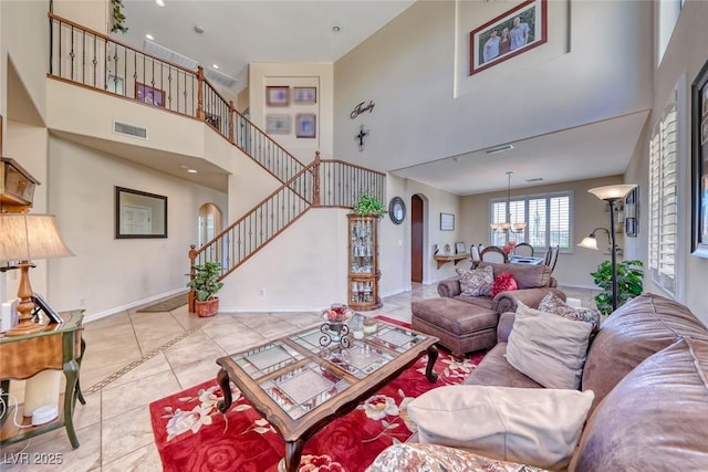 2733 Auchmull St, Henderson, NV 89044 - tiled living room with arched walkways, a high ceiling, and stairway