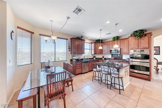 2733 Auchmull St, Henderson, NV 89044 - kitchen with appliances with stainless steel finishes, dark countertops, a kitchen breakfast bar, a center island, and recessed lighting