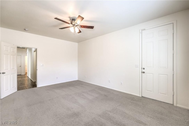 carpeted empty room featuring visible vents, baseboards, and ceiling fan