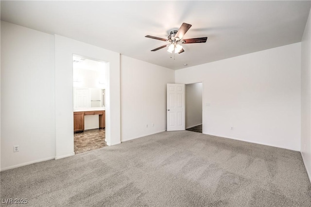 unfurnished bedroom featuring ceiling fan, carpet floors, ensuite bathroom, and baseboards