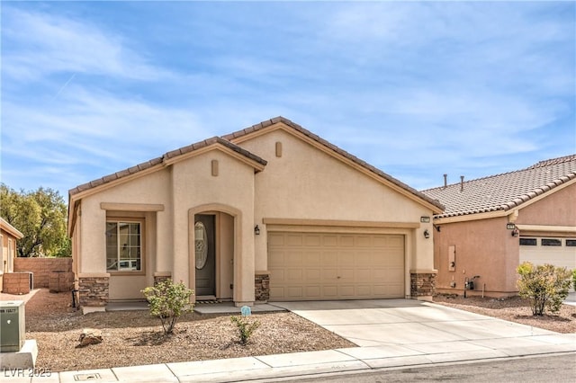 mediterranean / spanish-style home featuring a garage, driveway, stone siding, and stucco siding