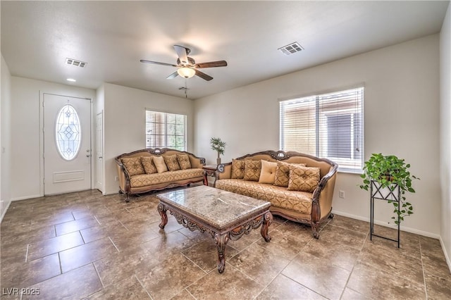living room with visible vents, a ceiling fan, and baseboards